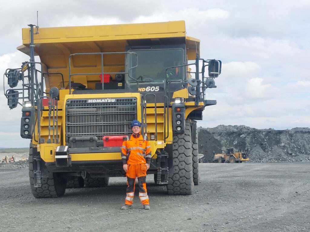 Komatsu HD605 ja työntekijä